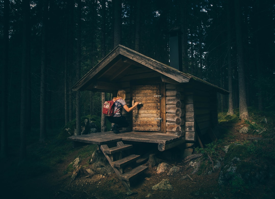Cabin in the woods by Daily Checklist girl knocking on wooden door