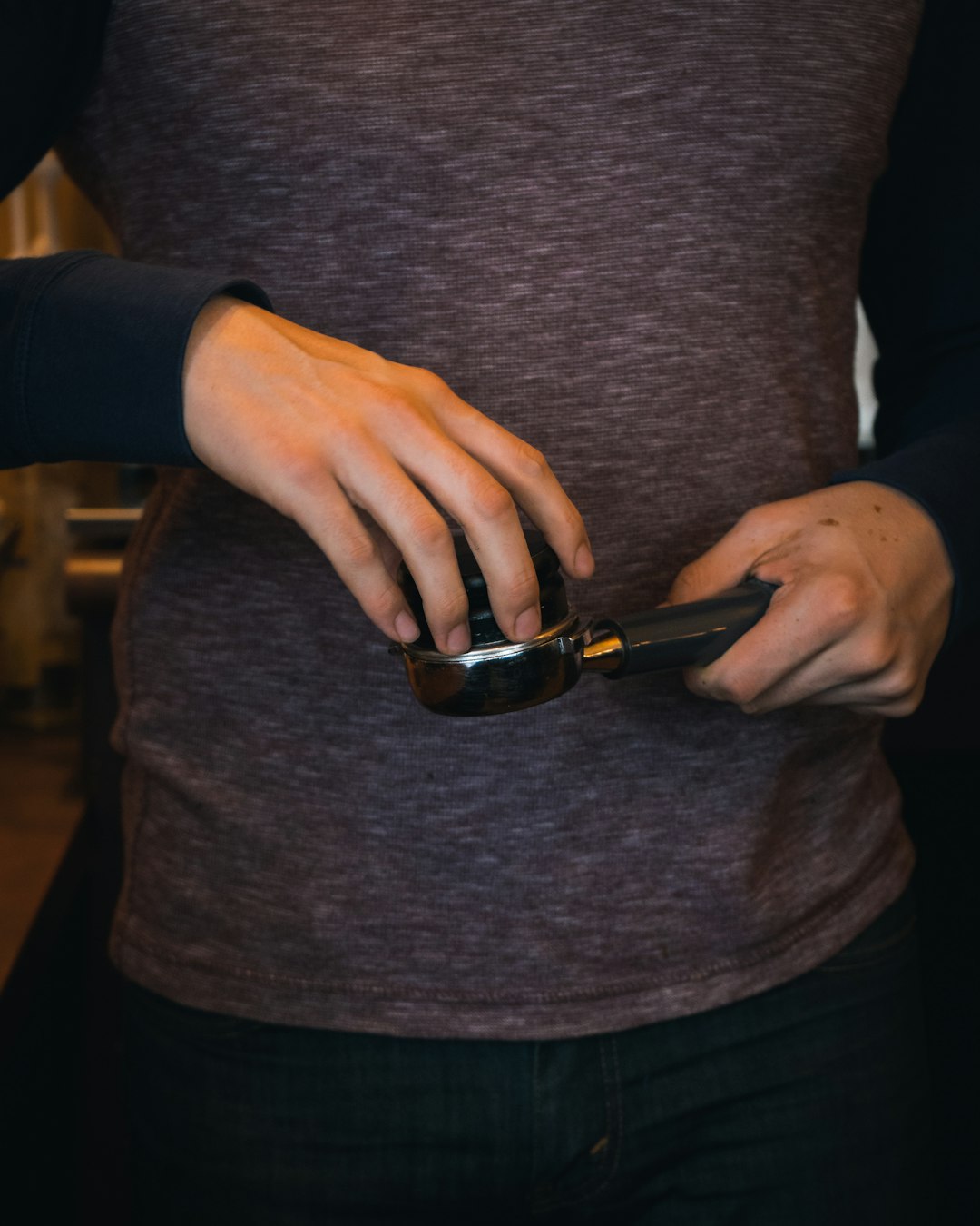 person in gray sweater holding black smartphone